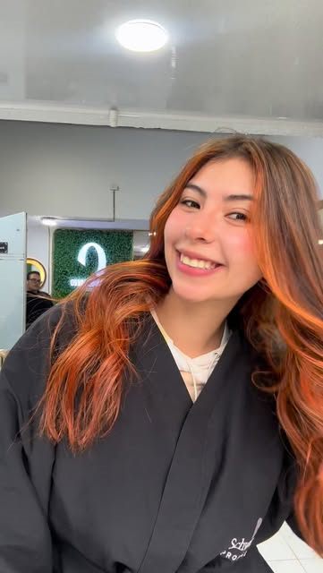 Clienta sonriente con cabello cobrizo encendido