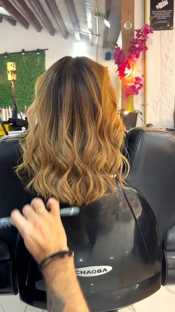 Estilista dando forma a unas ondas doradas