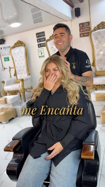 Osvaldo Muñoz junto a una clienta emocionada, al fondo las sillas blancas y doradas del salón