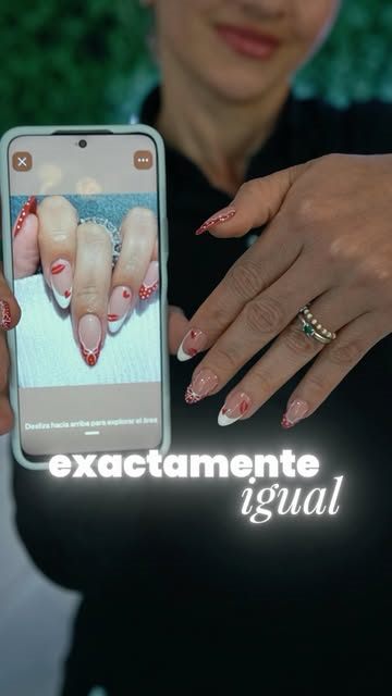 Manos con uñas diseñadas junto a un celular con la foto de referencia